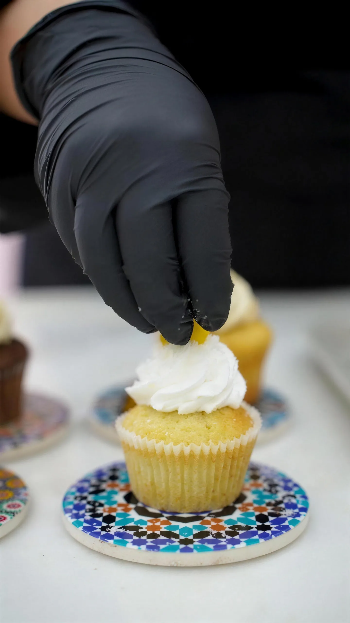 Sahar décore un cupcake dans l'atelier O'Sweet
